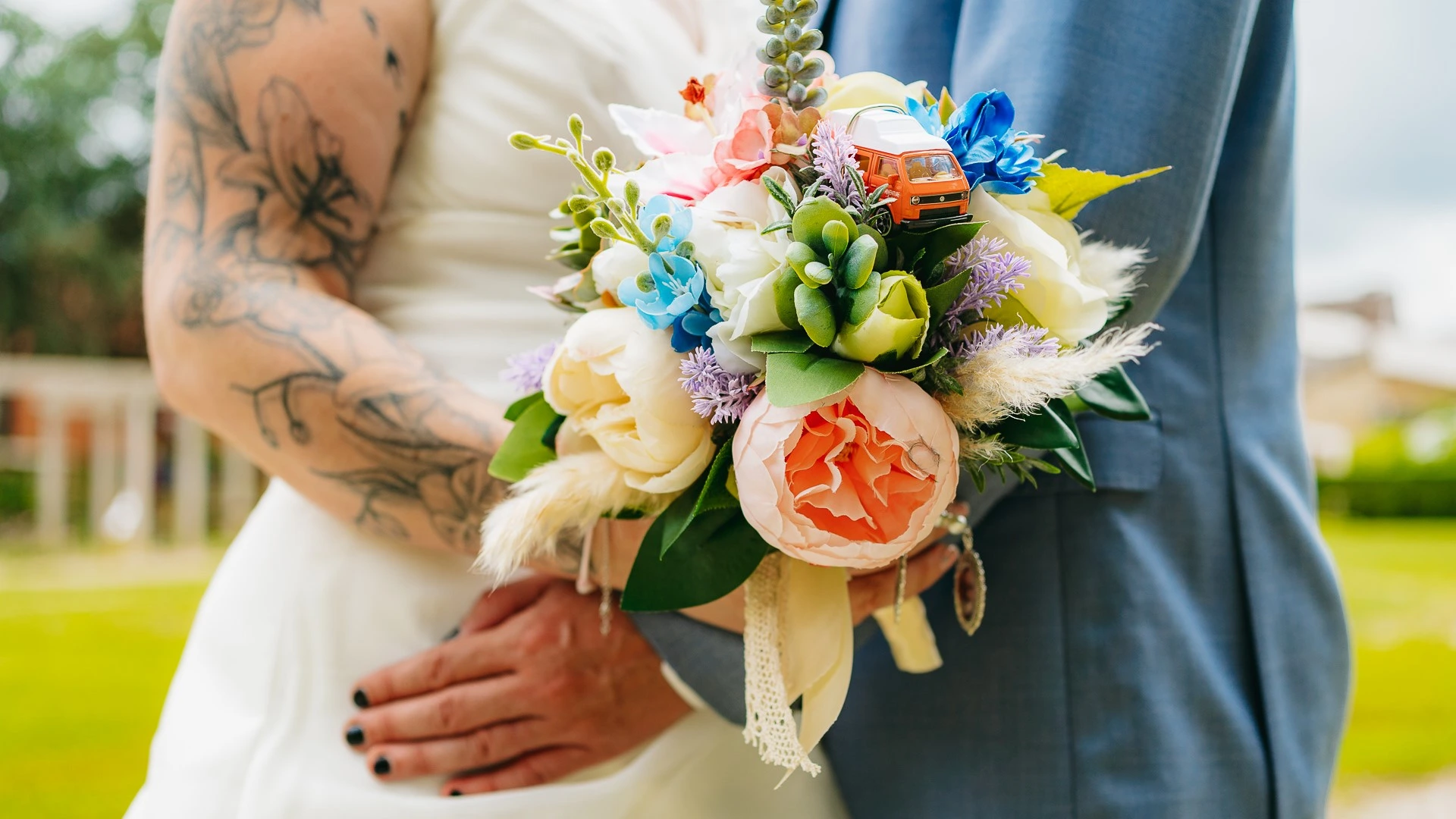 Une mariée et un marié tatoués tenant un bouquet