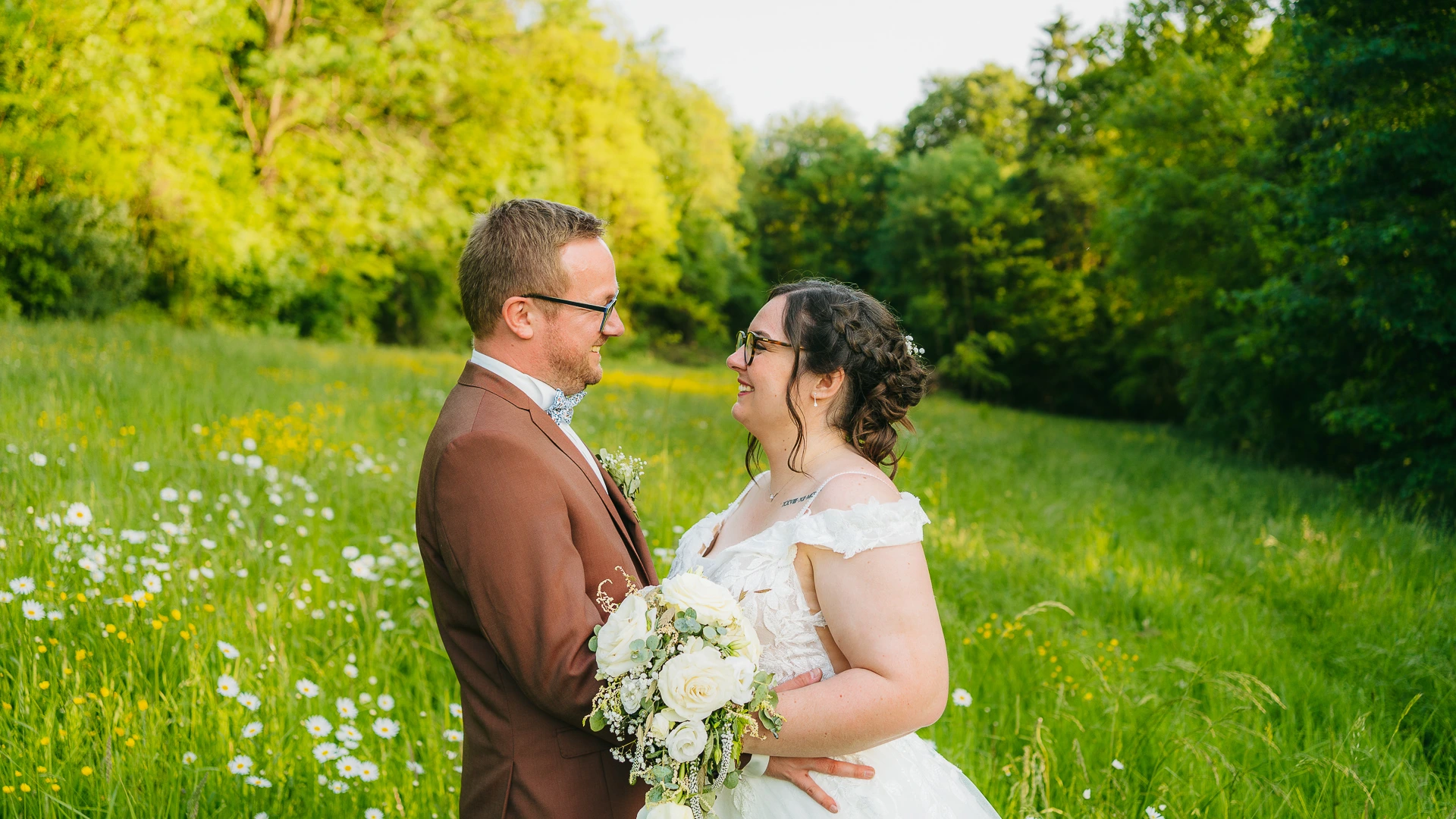 Une mariée et un marié dans un champ de marguerites