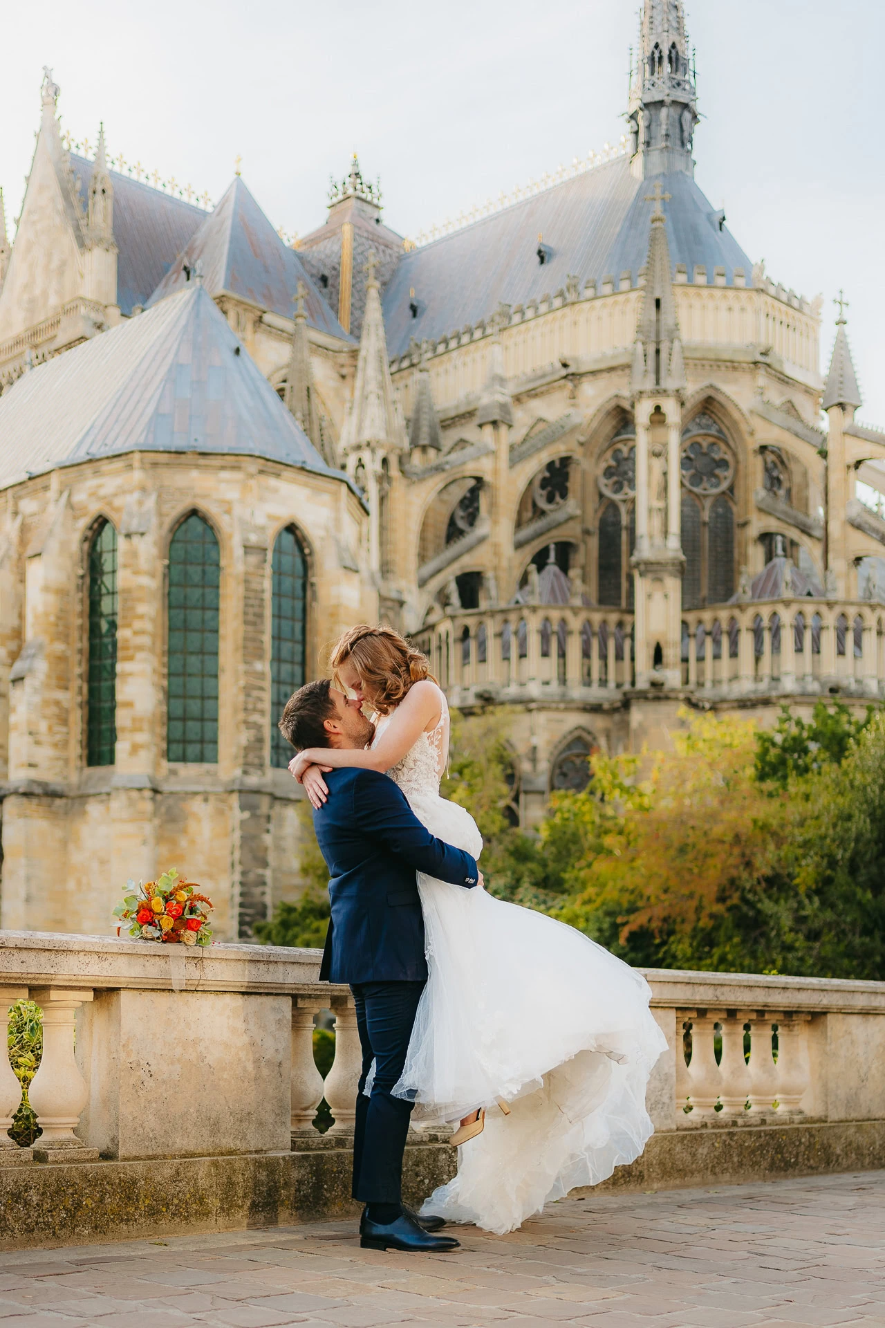 Couple s'embrassant devant une cathédrale gothique