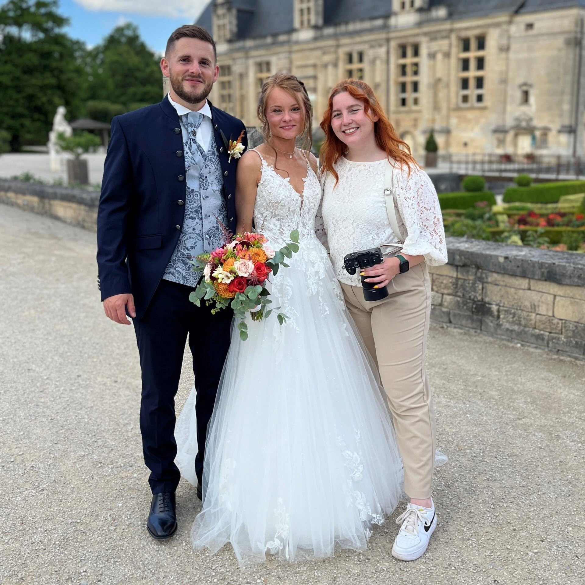 Les mariés posent pour une photo devant un château.